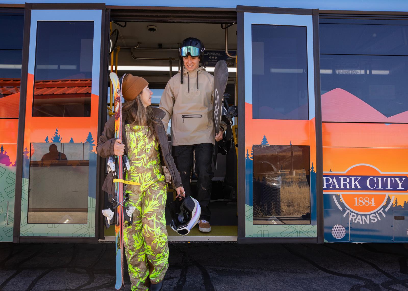 A skiier and snowboarder getting off a park city transit bus